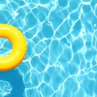 Foto de una piscina agua cristalina y un flotador amarillo en ella. Cómo poner el agua de la piscina cristalina.