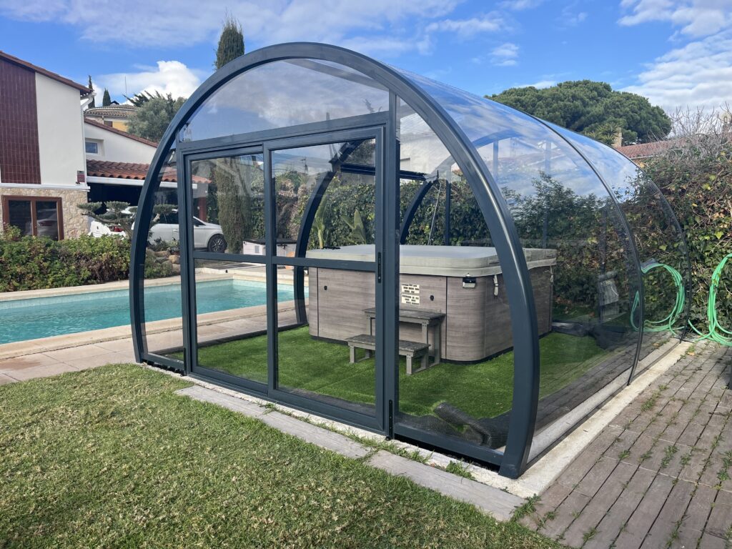 Promocions Cubierta Vision instalada en un jardín junto a una piscina protegiendo un spa.